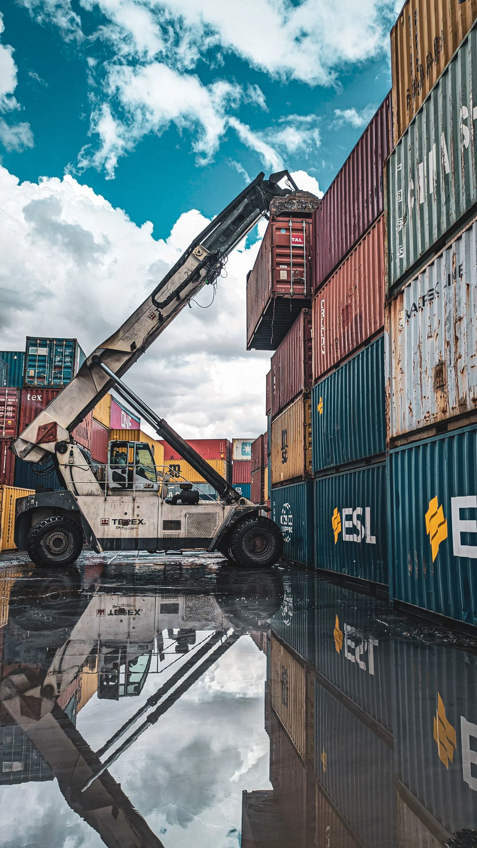 A container-handling vehicle lifting a shipping container